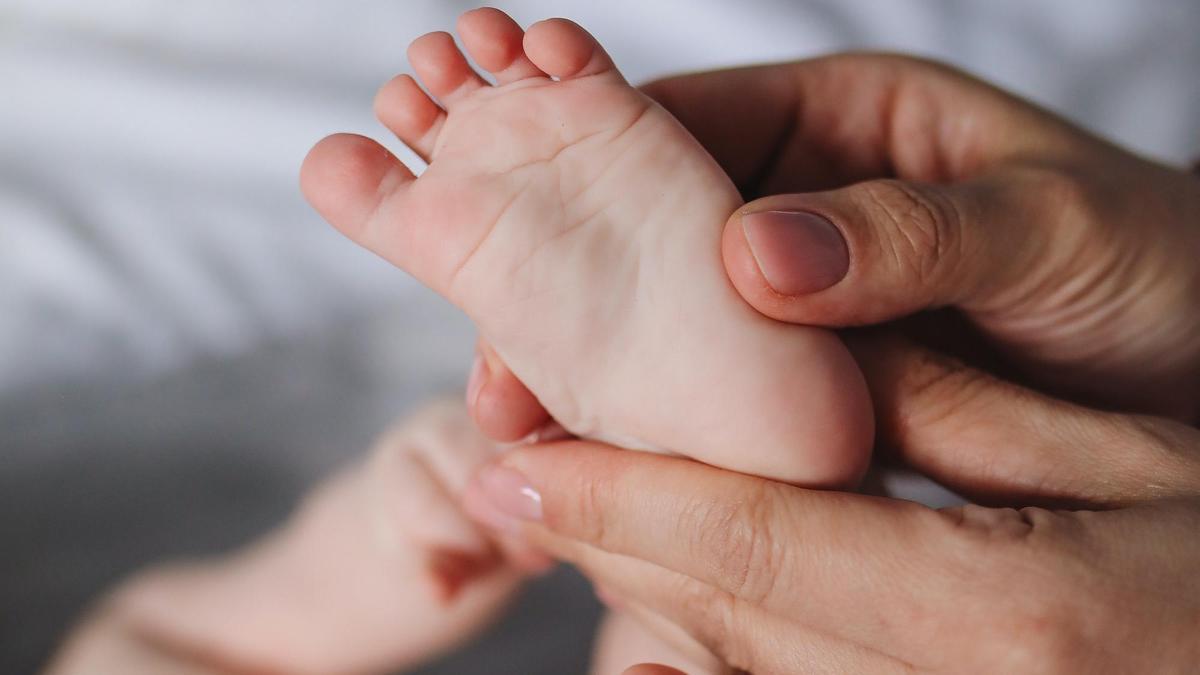 Un padre acaricia el pie de un bebé