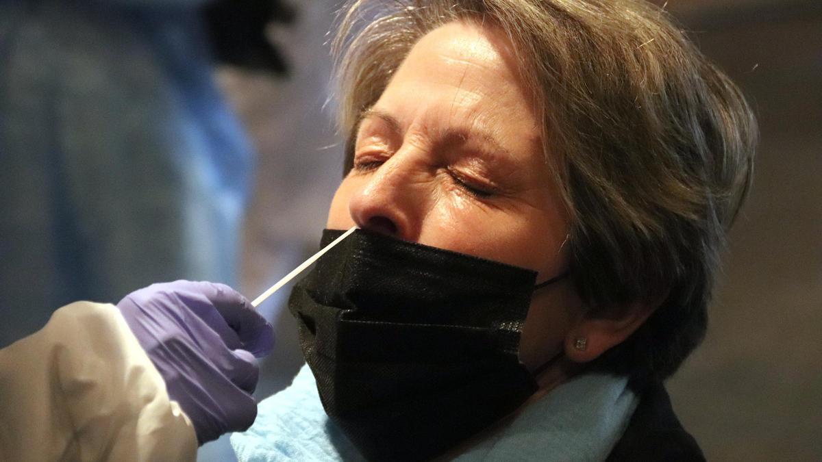 Una dona amb els ulls tancats mentre li extreuen una mostra de PCR
