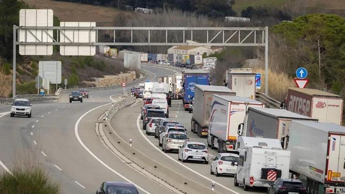 Filas de camiones y coches parados en una carretera.