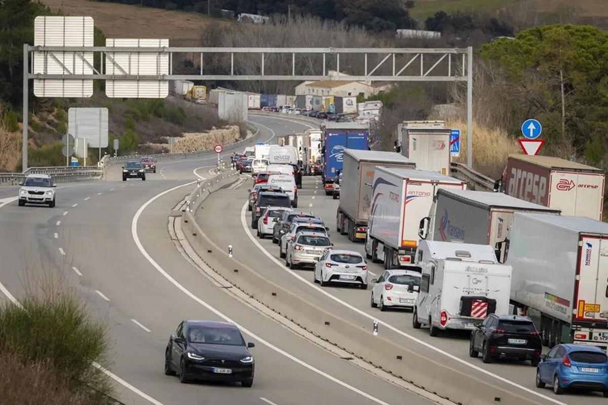Filas de camiones y coches parados en una carretera.