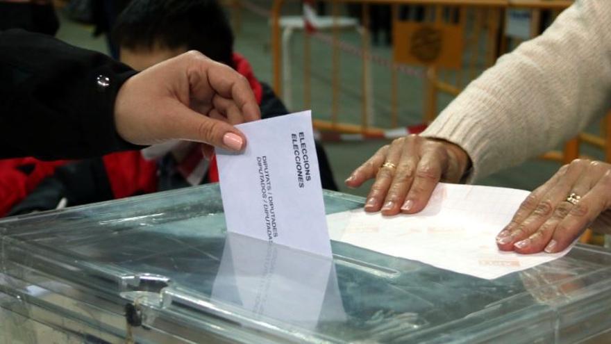 Pla detall d&#039;una urna i de la mà d&#039;una persona votant al col·legi electoral de la Tàrraco Arena Plaça de Tarragona durant les primeres hores de la jornada electoral del 14-F