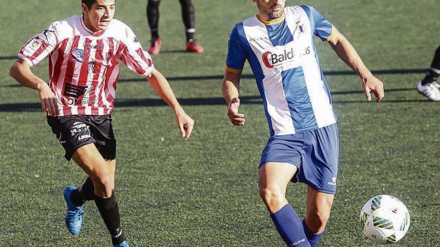 Jorge Rodríguez, del Avilés, da un pase acosado por un jugador del Siero.