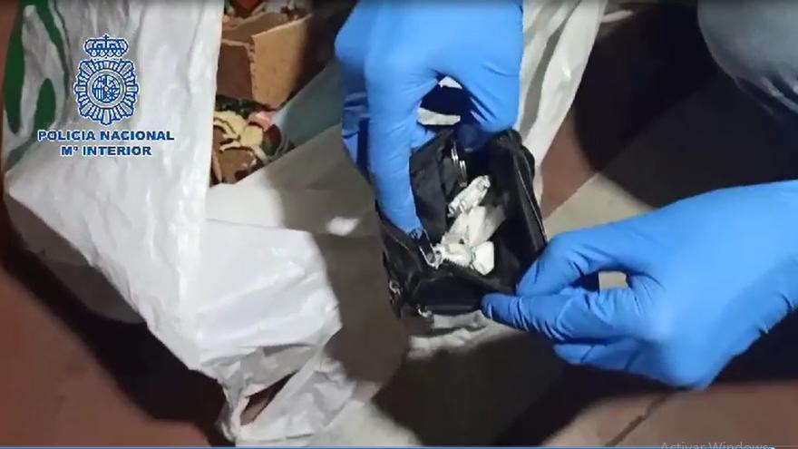 Un agente enseña dosis de cocaína encontradas por un perro policía entre las pertenencias de los detenidos