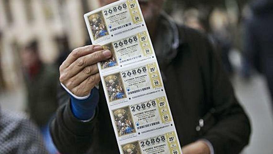 Un hombre muestra una tira de décimos del Sorteo de El Niño.