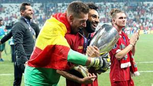 El guardameta Adrián San Miguel, abrazado a Salah que sostiene el trofeo de la Supercopa