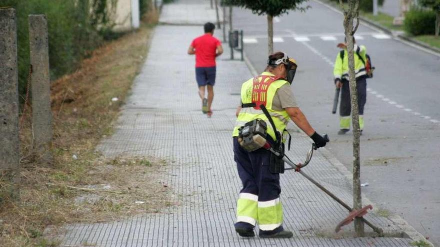 Operarios municipales realizando desbroces en la Rúa da Cultura, ayer por la tarde. // Bernabé/Luismy