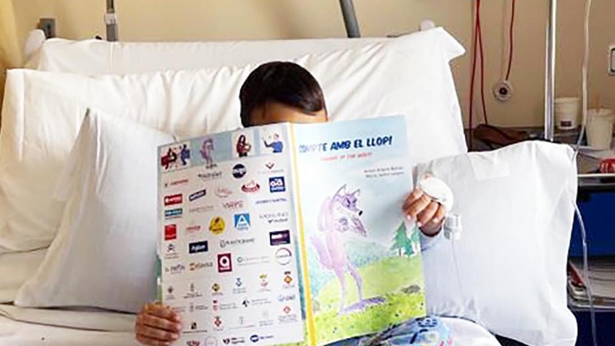 Un nen hospitalitzat amb el llibre 'Compte amb el llop'