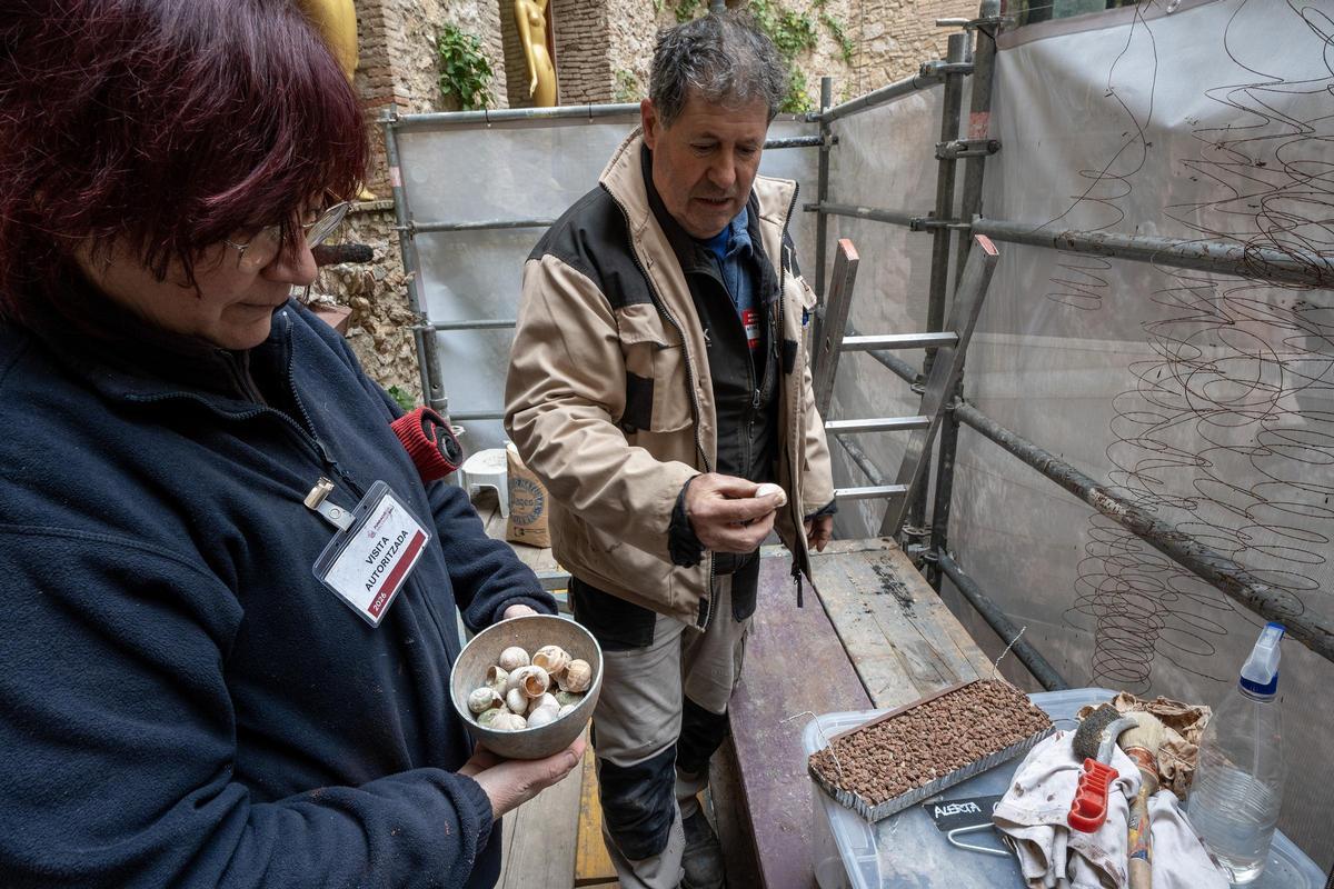 Anna Cusó i Pere Viñas mostrant alguns dels cargols que utilitzaran per restituir els que el temps ha fet malbé.