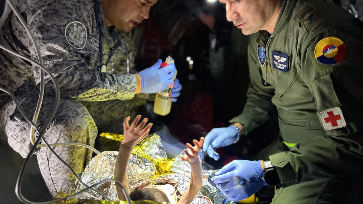 Dos soldados atienden a uno de los niños rescatados en la selva de Colombia a su llegada a Bogotá, este sábado.