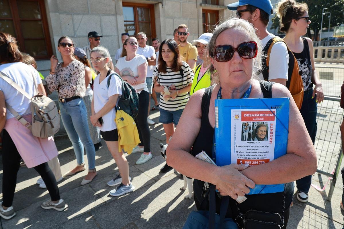 Una mujer con uno de los carteles de la desaparecida.