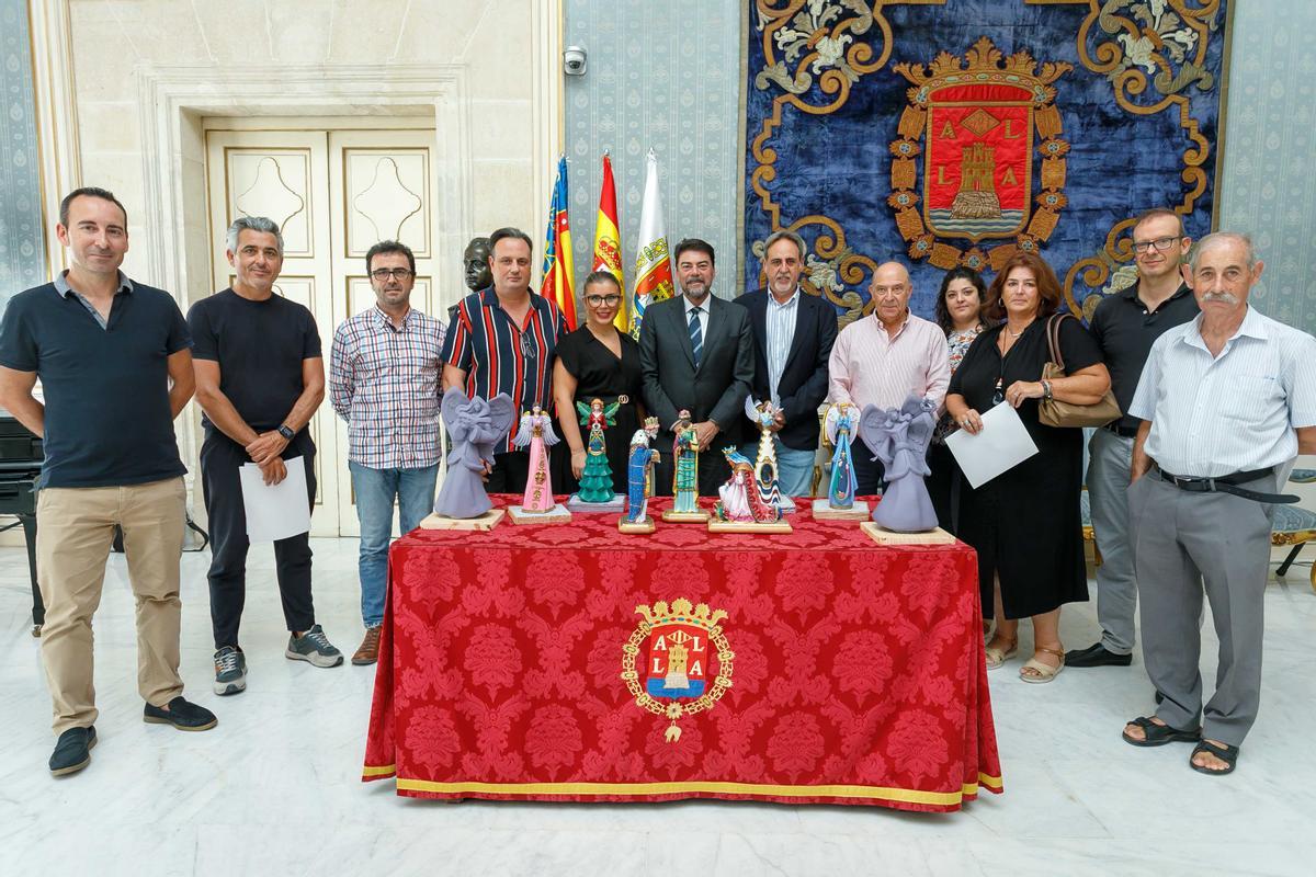 Los artistas y miembros del gobierno local posan junto a las maquetas.