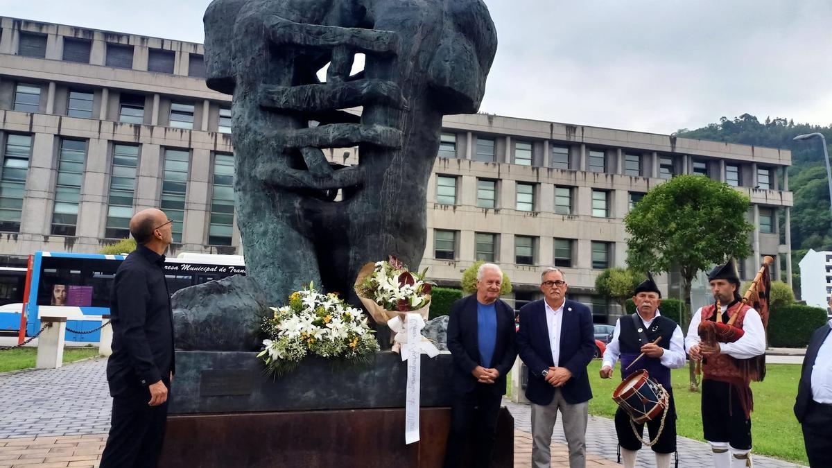 Ofrenda floral en el monumento al minero con Carlos Ruiz de Arcaute, director del Orfeón, a la izquierda, Víctor Manuel y Aníbal Vázquez. | D. O.