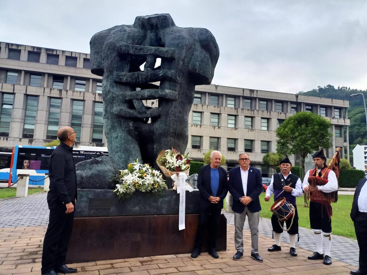 Ofrenda floral en el monumento al minero con Carlos Ruiz de Arcaute, director del Orfeón, a la izquierda, Víctor Manuel y Aníbal Vázquez. | D. O.
