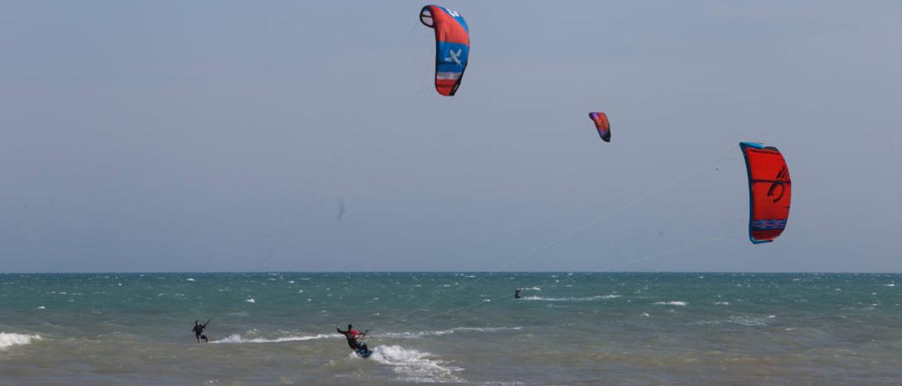 Bañistas aprovechan el viento para practicar «kitesurf» en la playa de San Juan.