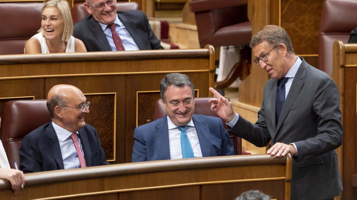 El líder del PP, Alberto Núñez Feijóo, charla con los diputados del PNV en el pleno de su investidura el pasado septiembre.