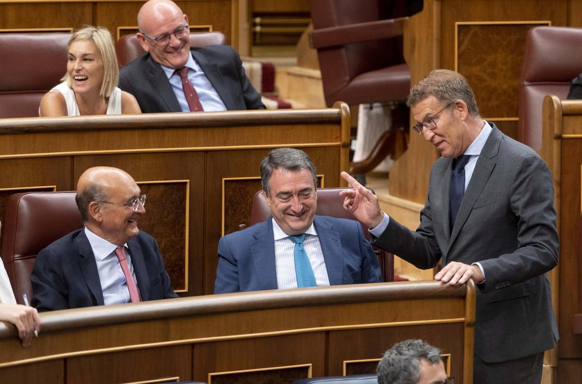 El líder del PP, Alberto Núñez Feijóo, charla con los diputados del PNV en el pleno de su investidura el pasado septiembre.