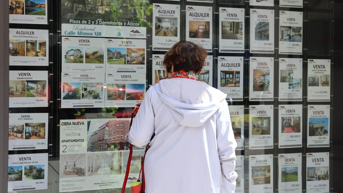 Una mujer observa el escaparate de una inmobiliaria en Vigo.
