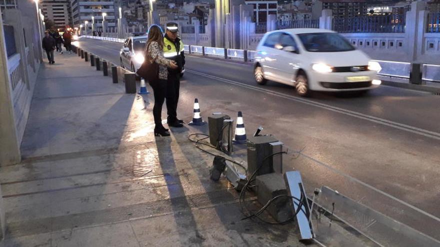 Imagen de las protecciones reventadas del puente de San Jorge, con un vehículo de la Policía Local al fondo.