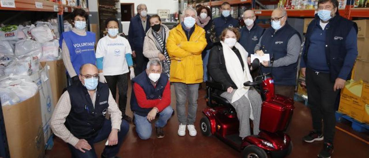 Ana Estévez, en su nueva moto adaptada, entrega ayer en el Banco de Alimentos de Vigo el dinero recaudado.   | // ALBA VILLAR