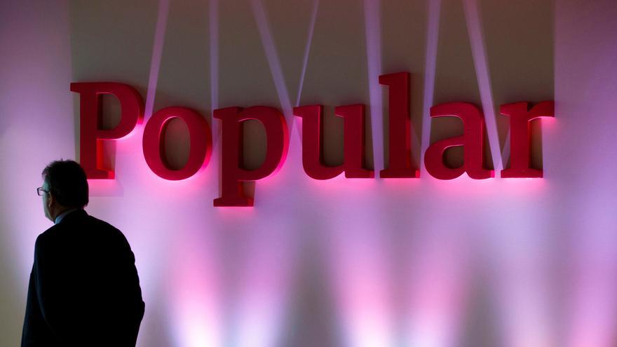 Foto de archivo de un hombre frente al logo del Banco Popular.