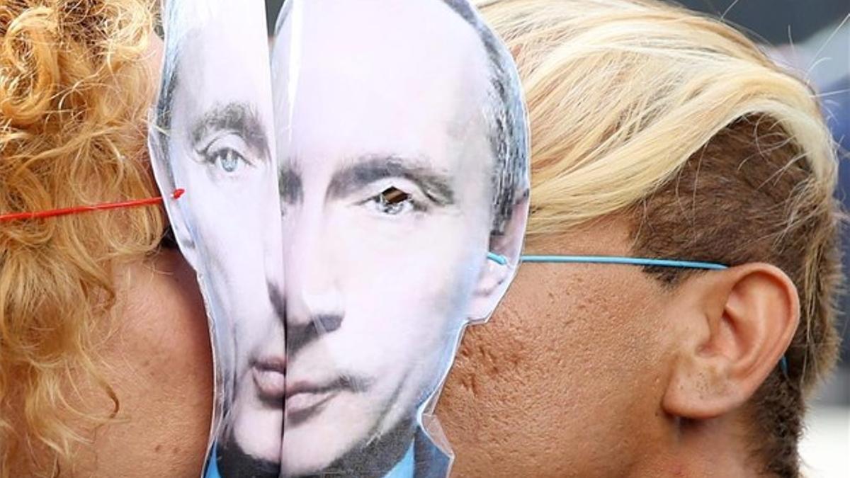 Una pareja, con caretas de Vladimir Putin, se besa durante la protesta contra la discriminación sexual realizada el pasado domingo en París