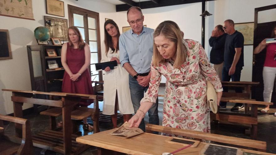 Ana Pastor observa un cuaderno en el Aula de la Escuela Rural de Ibias, acompañada por el coordinador del Foro, Luis Felipe Fernández, la alcaldesa, Gema Álvarez, y la directora del colegio, Tania Domínguez. A la izquierda, firmando en el Ayuntamiento. | S. Arias