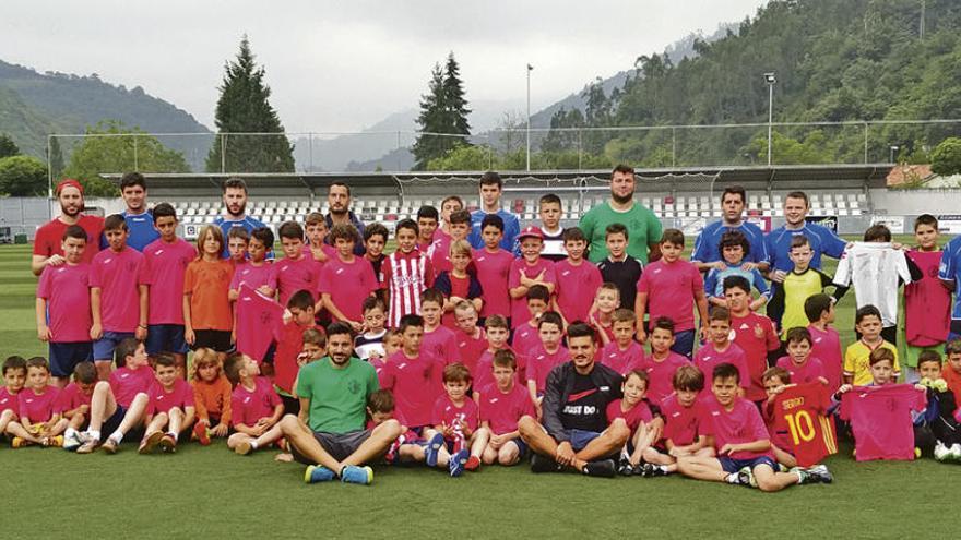 Los rojiblancos Canella y Sergio posan con los participantes en la sexta edición del campus Rober Canella.