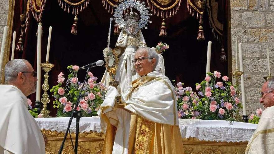 El obispo levanta la Custodia y tras él, la Virgen de la Concha .