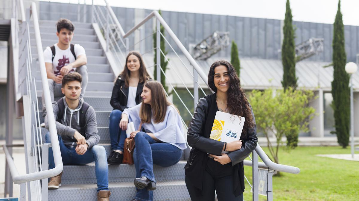 Grupo de estudiantes conversando al aire libre en el campus de la Universidad Pablo de Olavide