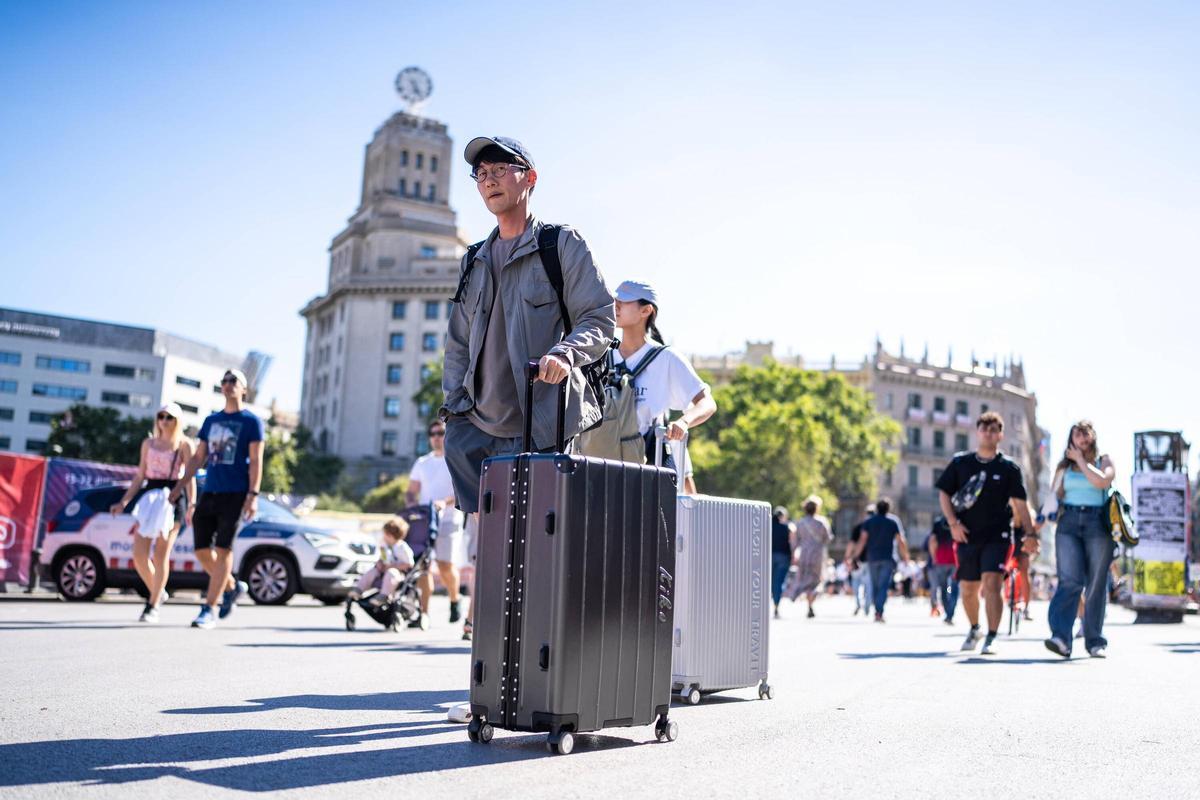 Turistas pasean con sus maletas, por el centro de Barcelona. Foto archivo