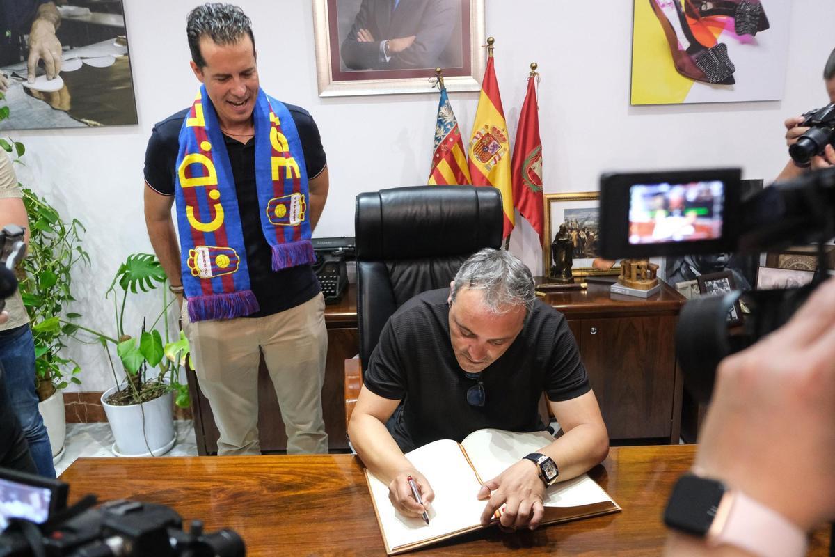Pascual Pérez firma en el libro de honor del Ayuntamiento de Elda en presencia del alcalde Rubén Alfaro, tras el ascenso del Eldense.