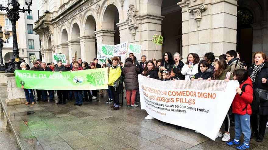 Vecinos del Agra, con una pancarta verde, hoy a la entrada del pleno.