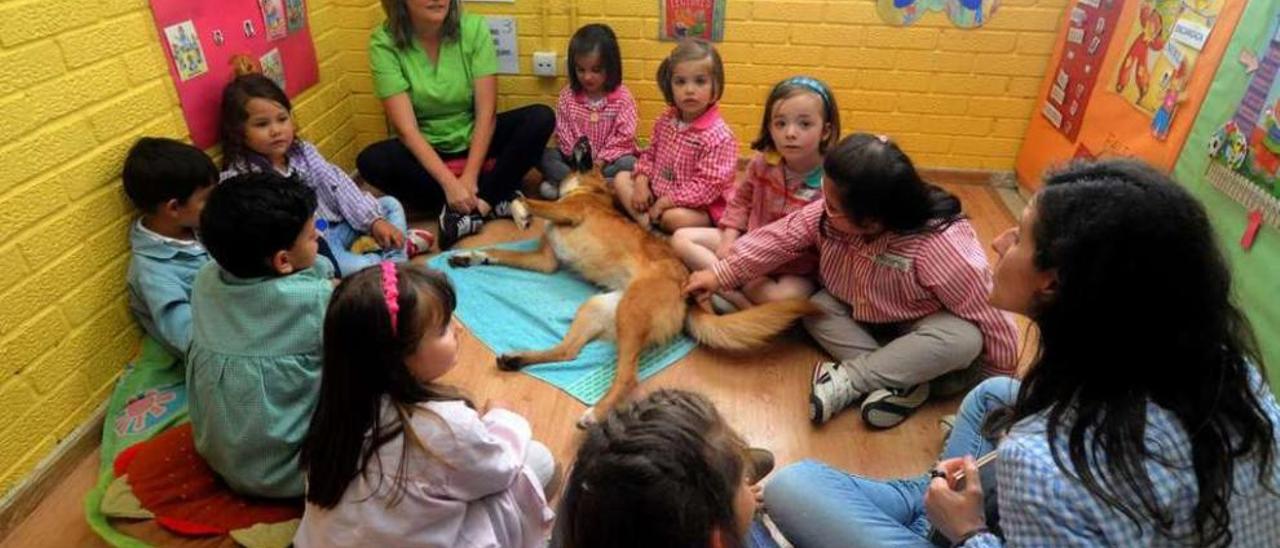 Los niños leen un cuento a &quot;Clau&quot; en la zona de relajación. // Iñaki Abella