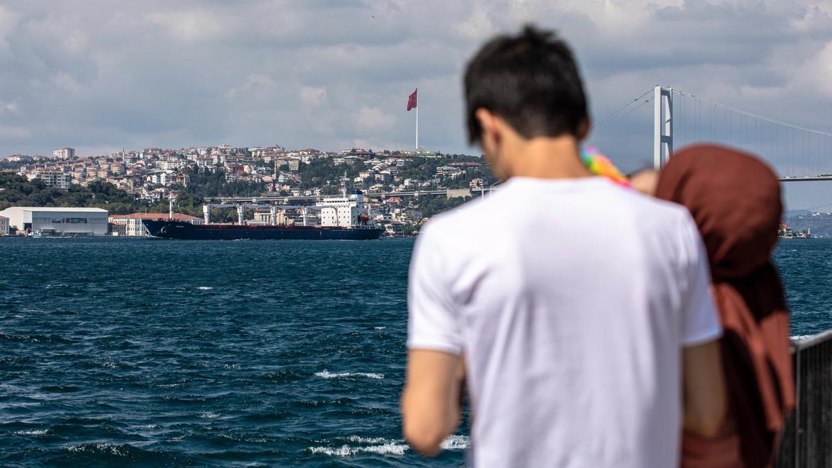 Dos personas observan el buque de carga con bandera de Sierra Leona Razoni, que transporta grano ucraniano.