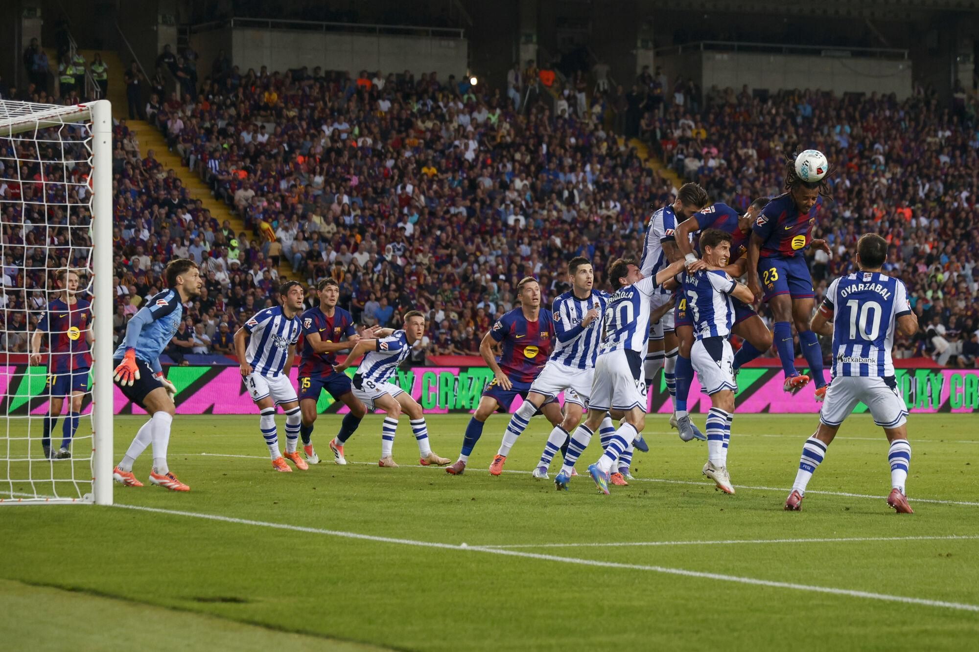 BARCELONA, 28/09/2025.- El defensa francés del FC Barcelona, Jules Koundé (2d), cabecea el balón ante los jugadores de la Real Sociedad en la jugada que ha significado el primer gol del equipo blaugrana durante el encuentro correspondiente a la séptima jornada de Liga EA Sports que FC Barcelona y Real Sociedad disputan este domingo en el estadio de Montjuic, en Barcelona. EFE/Quique García.