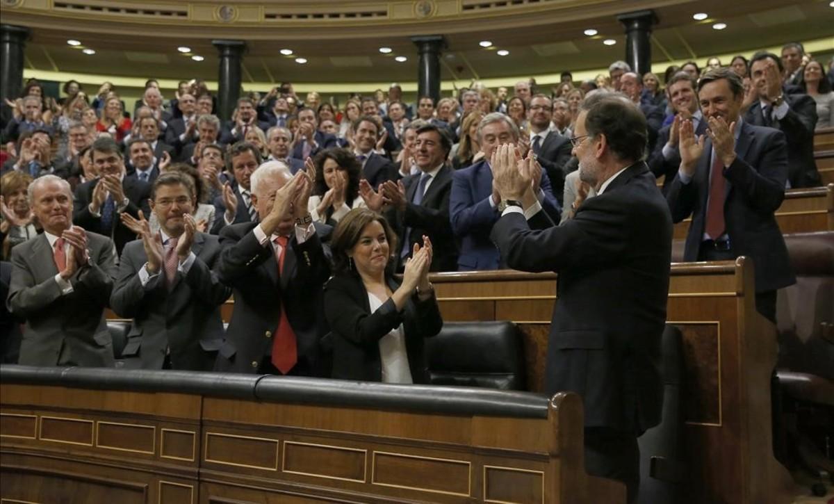 El grupo parlamentario, varios ministros y la vicepresidenta, Soraya Sáenz de Santamaría, aplauden a Mariano Rajoy tras ganar la votación del debate de investidura, el pasado sábado 29 de octubre.