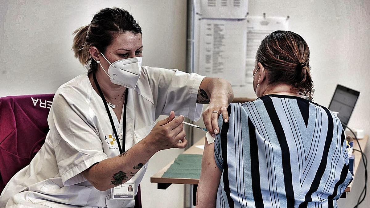 Una sanitaria vacuna a una mujer en un centro de Tenerife.