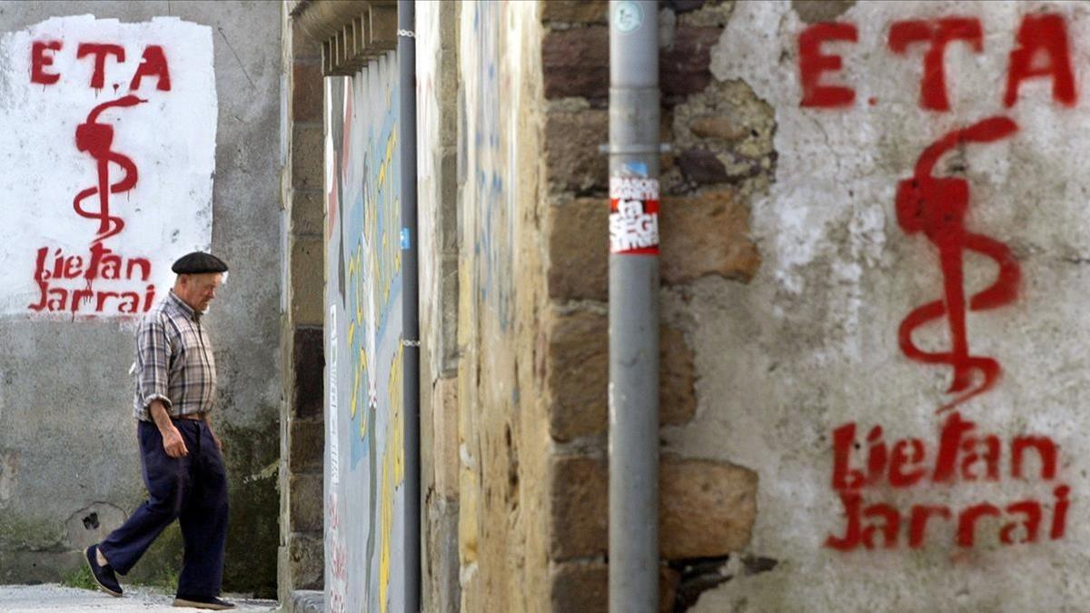 Un hombre pasa por delante de unas pintadas a favor de ETA, en Goizueta (Navarra).
