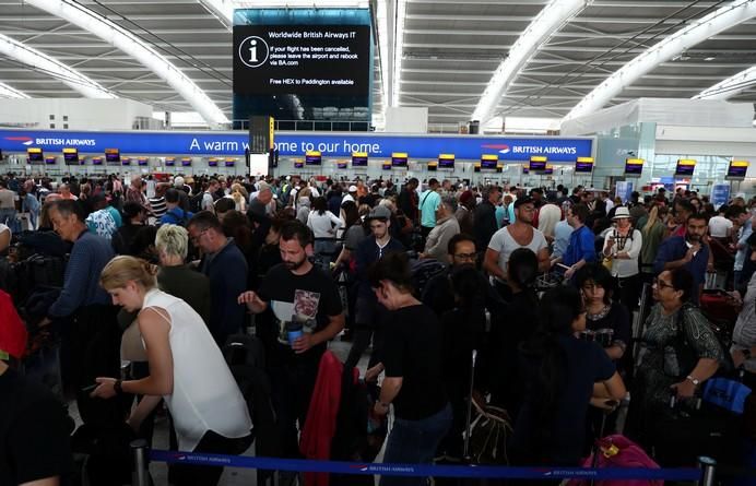 People wait with their luggage at the British ...