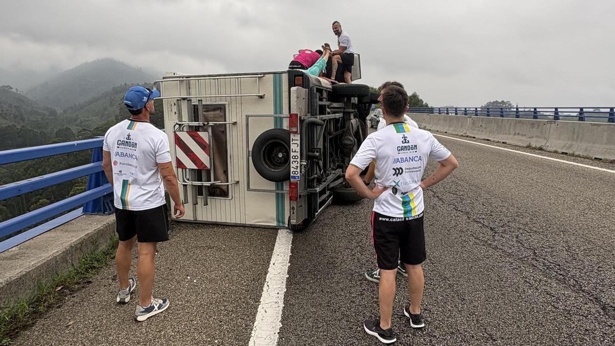 Carlos Pérez (con camiseta rosa) y Francisco Santos (a su lado) ayudan a sacar a la mujer de la autocaravana accidentada.