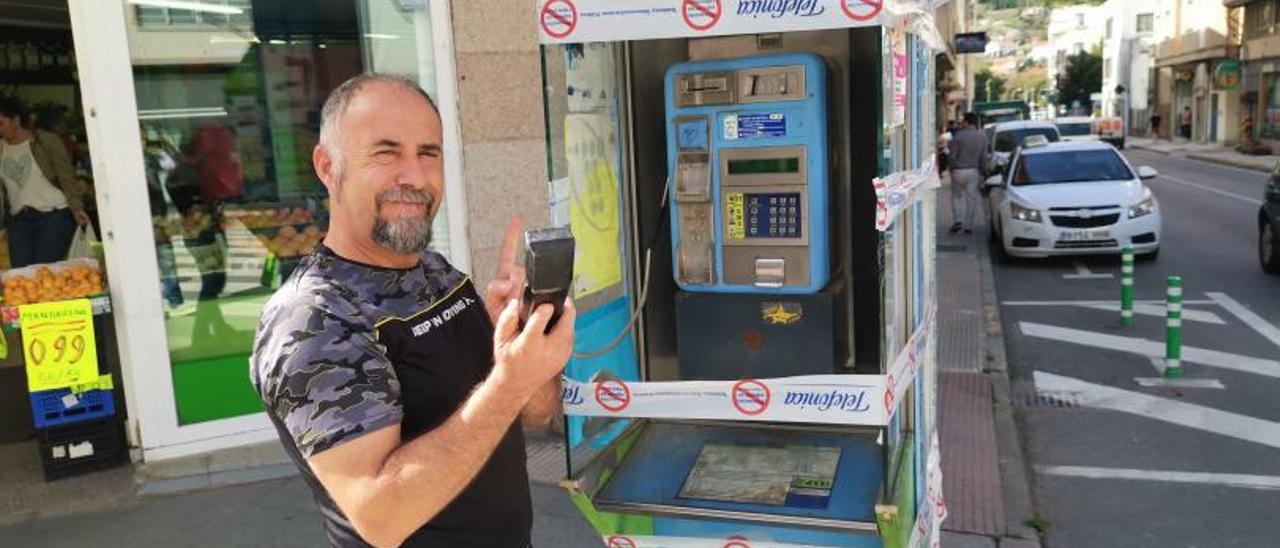 Un taxista de Bueu en la cabina telefónica precintada estos días. |   // SANTOS ÁLVAREZ