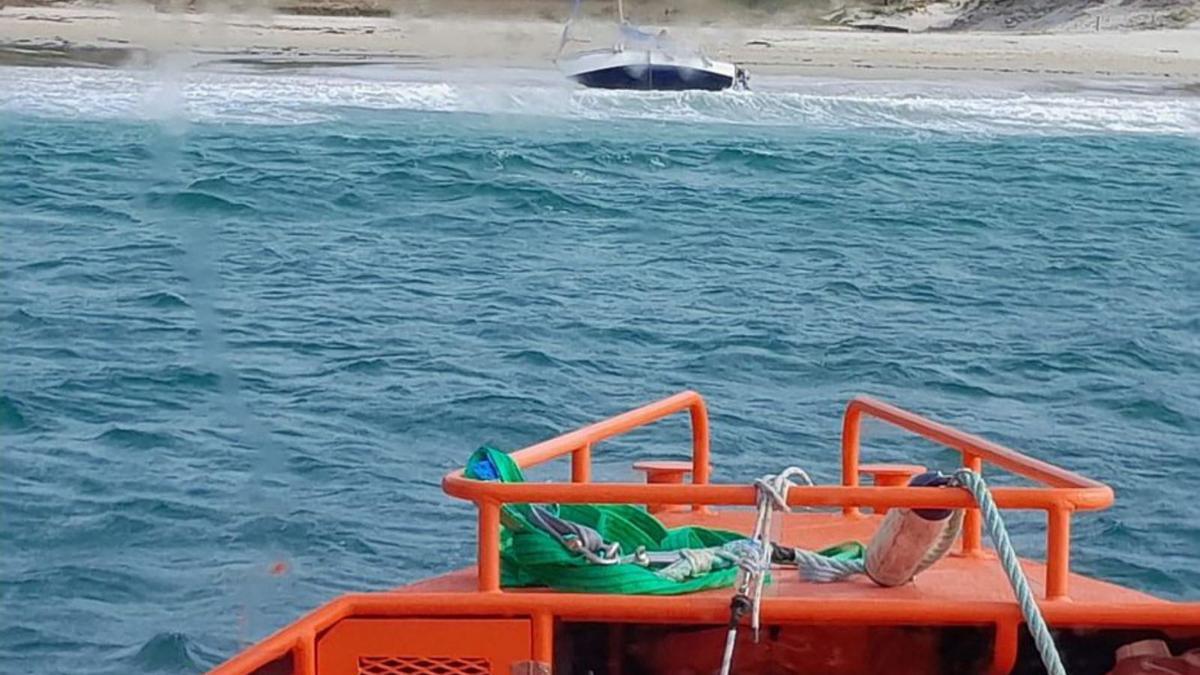 La Salvamar Mirach remolca la embarcación de la playa.   | // FARO