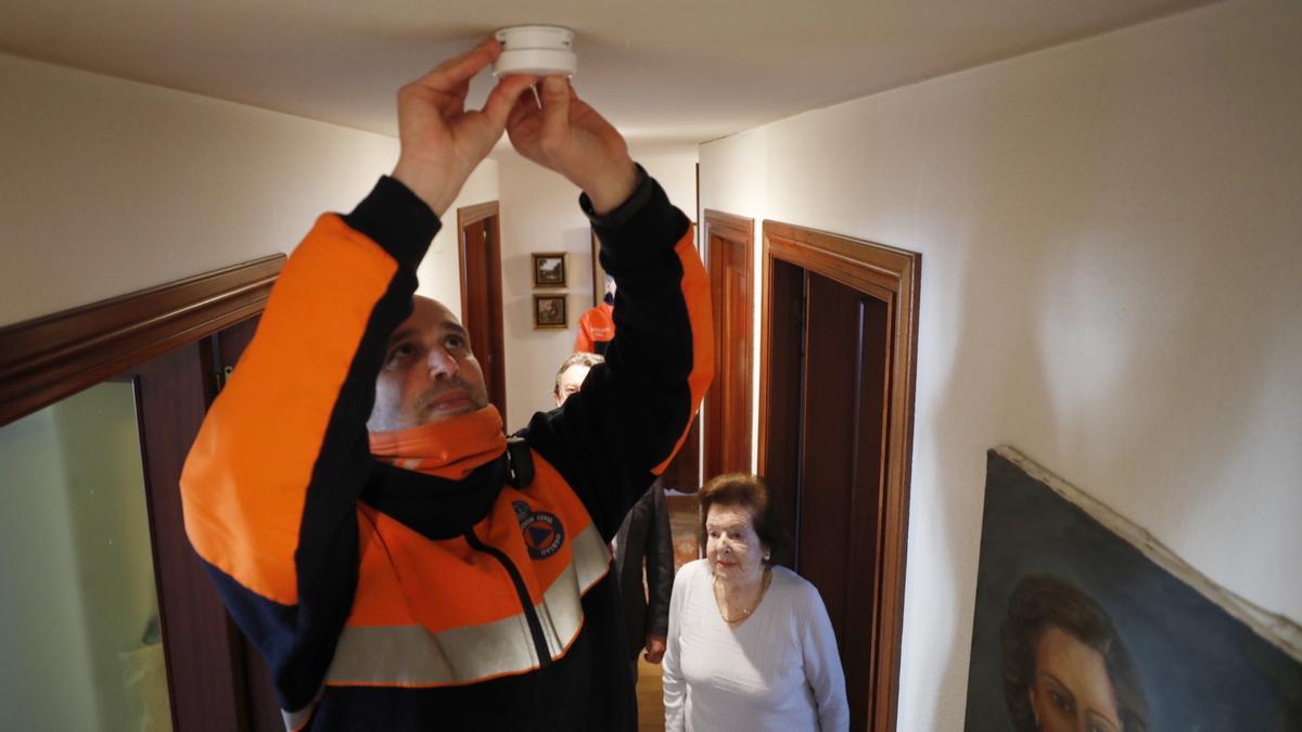 Un voluntario de protección civil coloca un detector en Oviedo