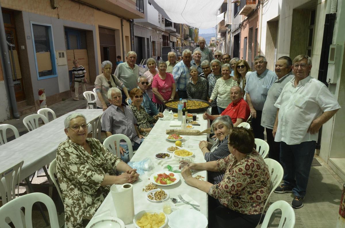 Un grupo numeroso de vecinos en su mesa durante la celebración.