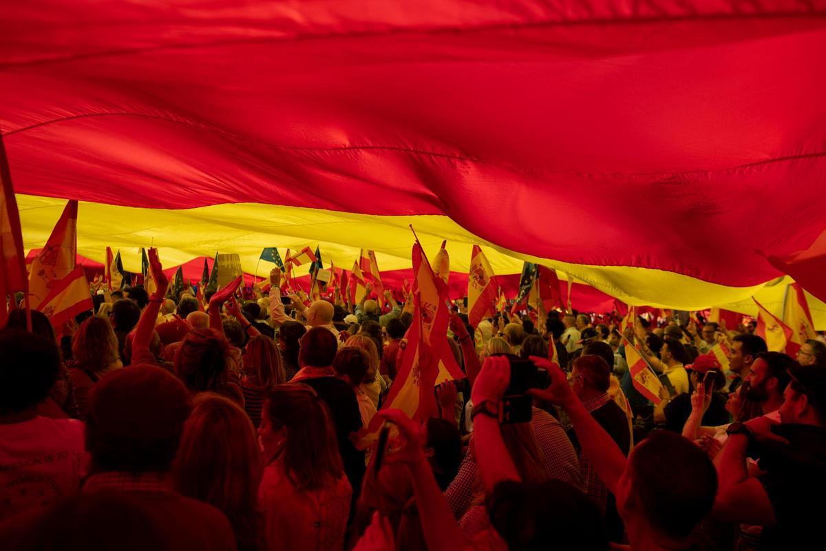 Los manifestantes marchan con una bandera gigante en Málaga durante una protesta convocada por la oposición de derecha contra un proyecto de ley de amnistía para las personas involucradas en el fallido intento de independencia de Catalunya de 2017, el 12 de noviembre de 2023.