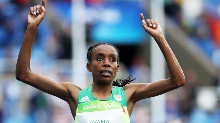 Almaz Ayana levanta los brazos en señal de victoria.