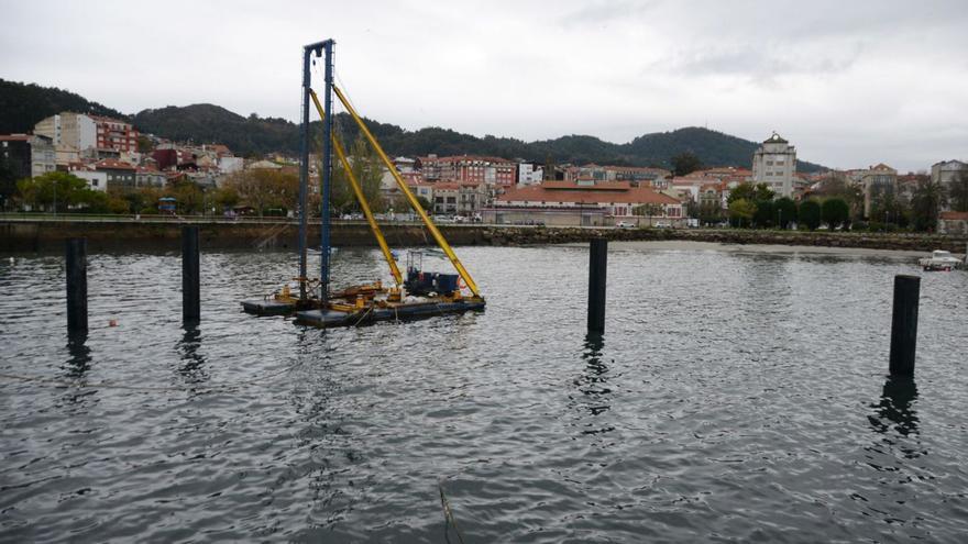 La pontona que trabaja en la colocación de los pilotes, ayer, en el muelle de Cangas.