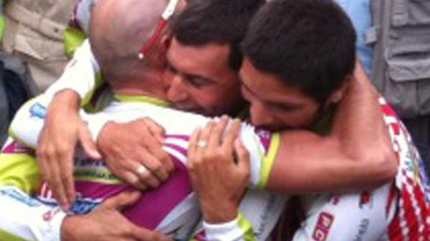 El ganador de la Vuelta de Asturias, Tino Zaballa, emocionado tras pasar por la línea de meta, se abraza con unos compañeros.