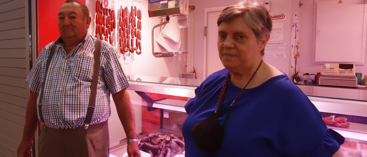 Dos pensionistas, José Luis y María, sostienen sus bolsas en el pasillo del Mercado Central.