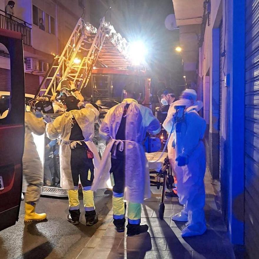 Los bomberos preparando la autoescalera para evacuar a la enferma por la ventana.